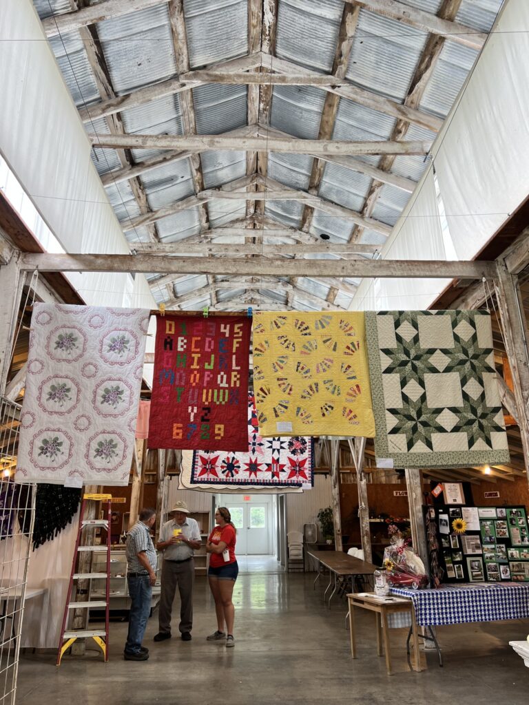 Quilts hang on display inside the barn at the Vinland Fair.